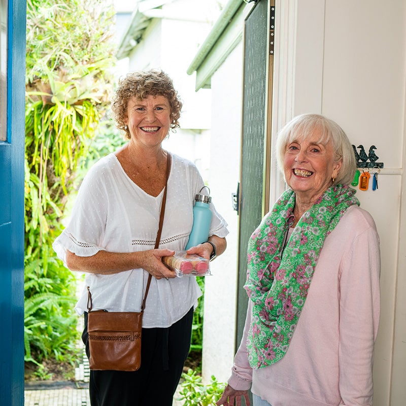 Volunteer and client Volunteer and client standing at front entry of client's home