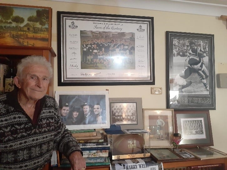 Photo of Harry Wells with Team of the Century photo on the wall in the background