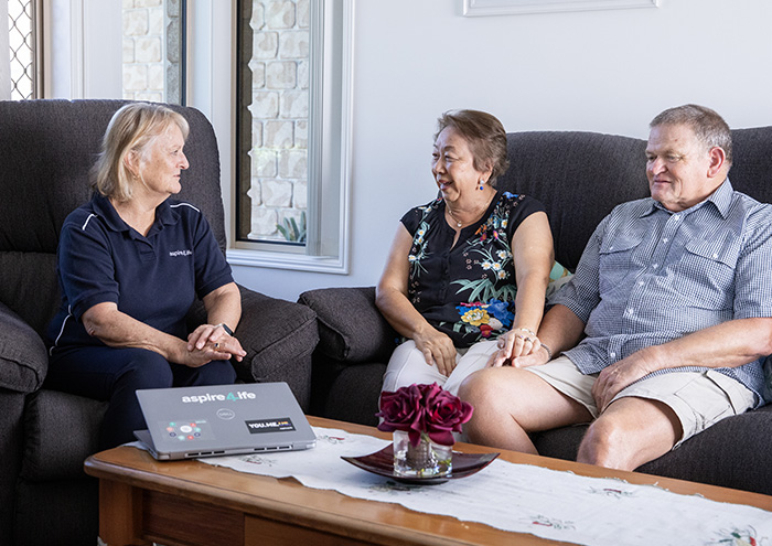 Photo of Aspire4Life Assessor talking to clients in their living room